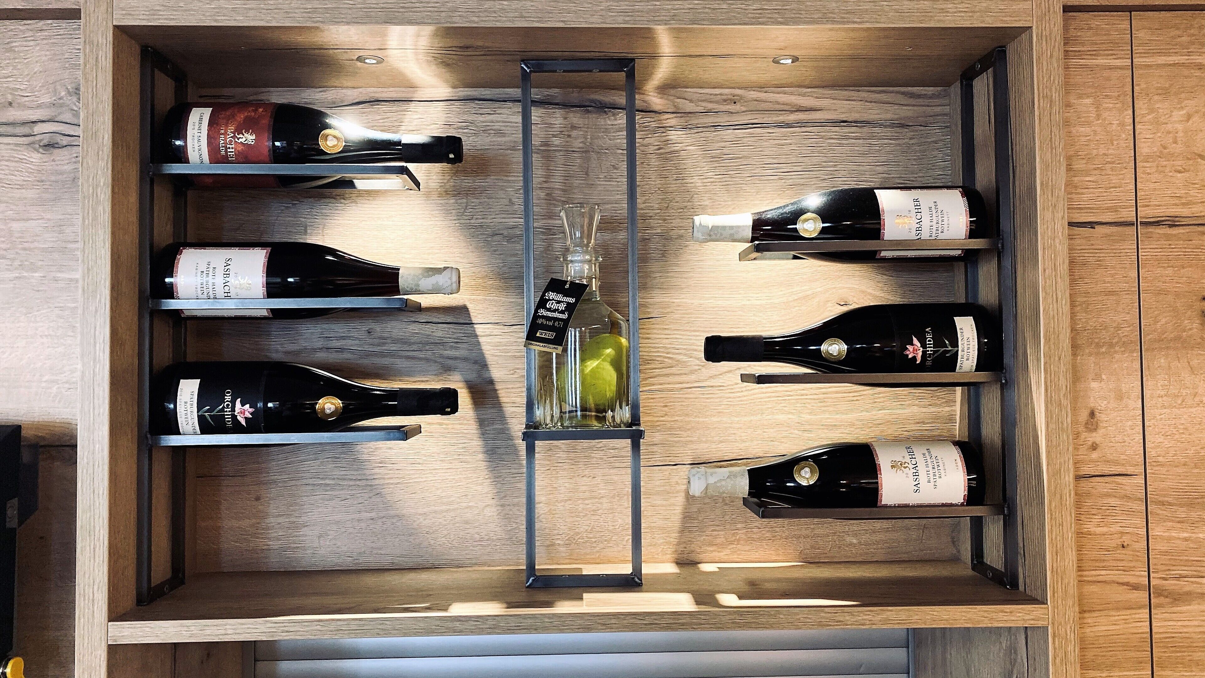 Un porte-bouteilles en bois contenant six bouteilles de vin.
