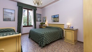A bedroom with a bed, a nightstand, a dresser, a chandelier, and framed pictures on the wall. - Zaguri Bed and Breakfast (Venice)