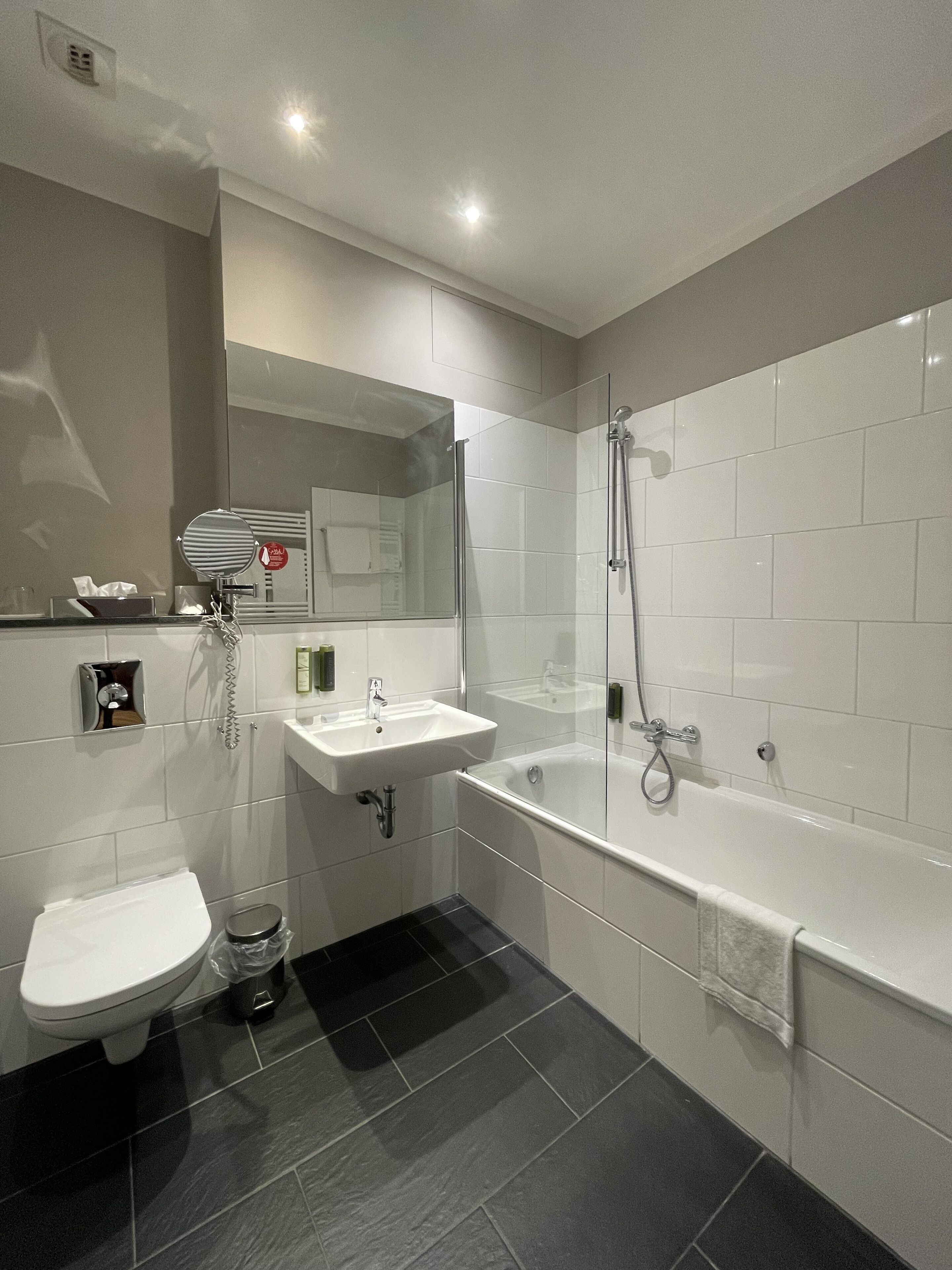 A modern bathroom with a toilet, sink, and bathtub.