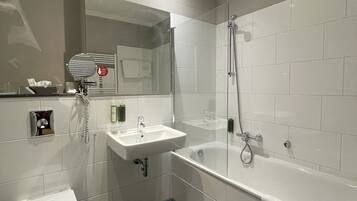 A modern bathroom with a toilet, sink, and bathtub.