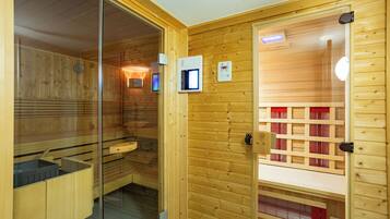 Un sauna avec des murs en bois, une porte en verre et un panneau de commande.