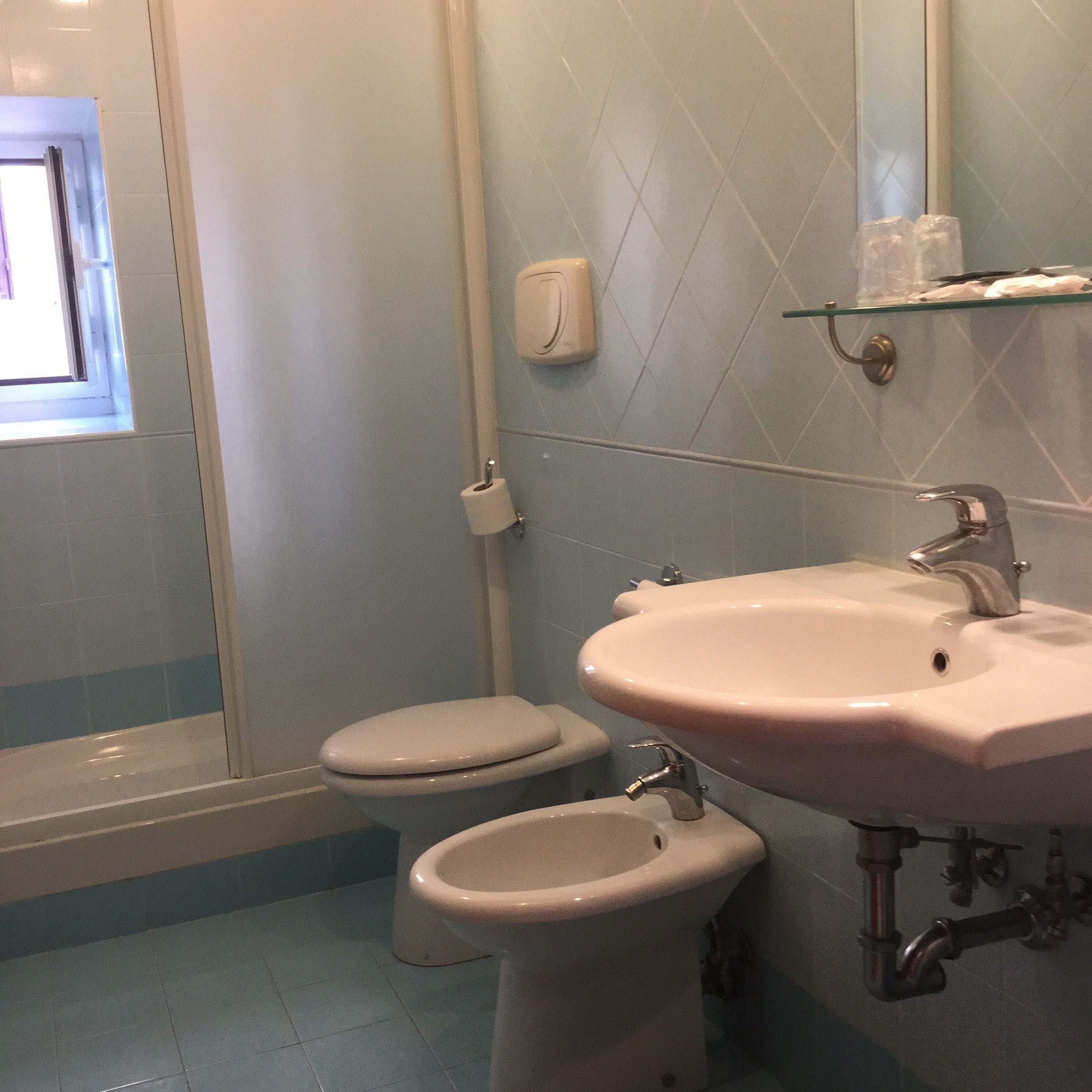 A bathroom with a toilet, bidet, and sink.