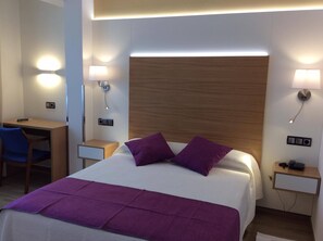 A hotel room with a bed, a desk, and two nightstands. - La Noyesa (O Grove)