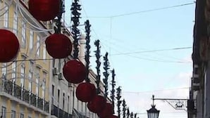 Una calle flanqueada por edificios, algunos con balcones y otros con ventanas.