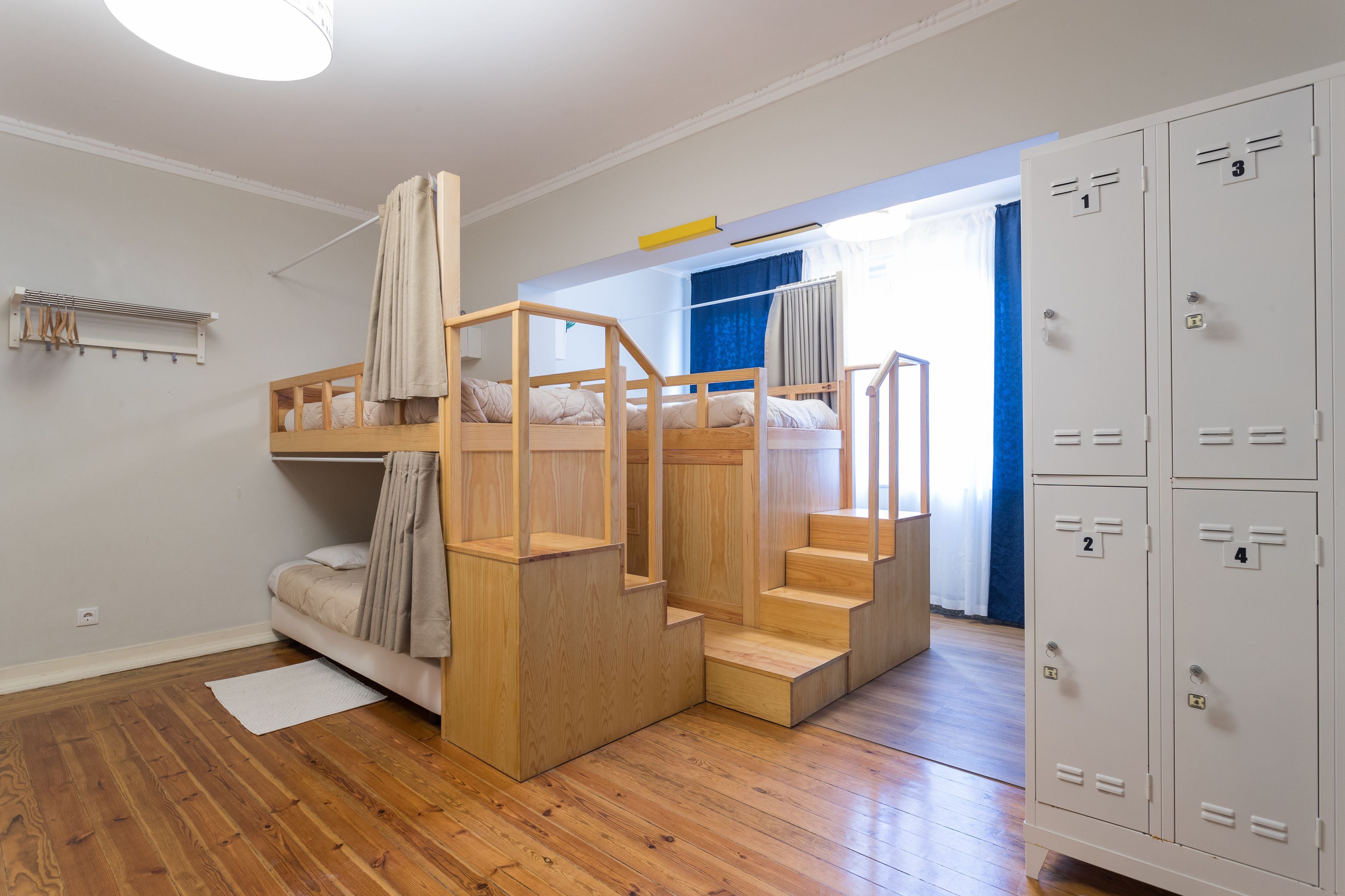 Une pièce avec un lit superposé, un escalier et une rangée de casiers.