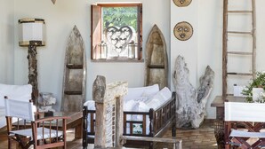 A rustic room with a wooden bed, a wooden table, and a chair. There are star decorations hanging from the ceiling and a ladder against the wall. - Ca' Maddalena (Villafranca di Verona)