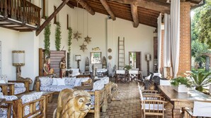 A rustic interior with wooden furniture, a lion statue, and a brick wall. - Ca' Maddalena (Villafranca di Verona)
