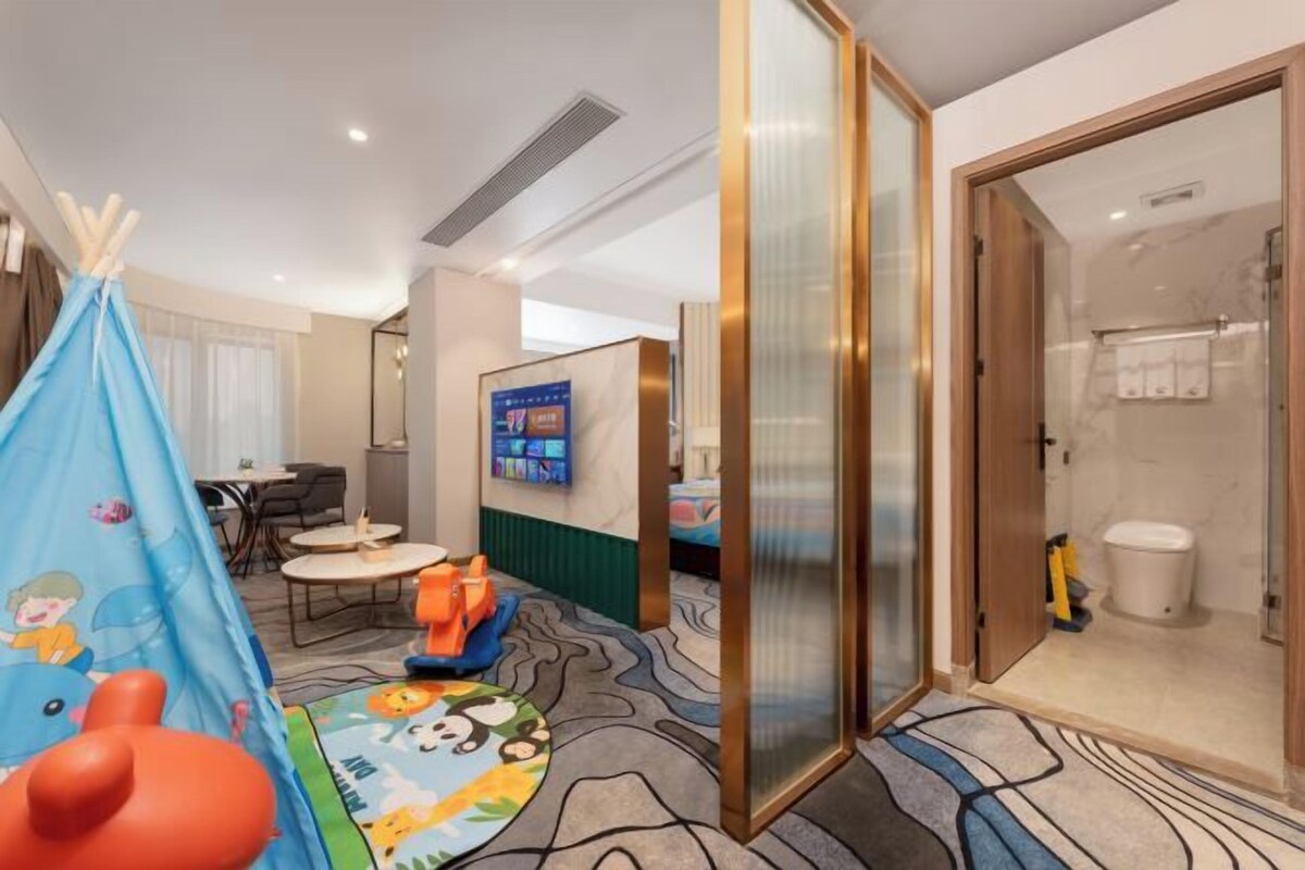 A hotel room with a tent, a TV, a bathroom, and a dining area.