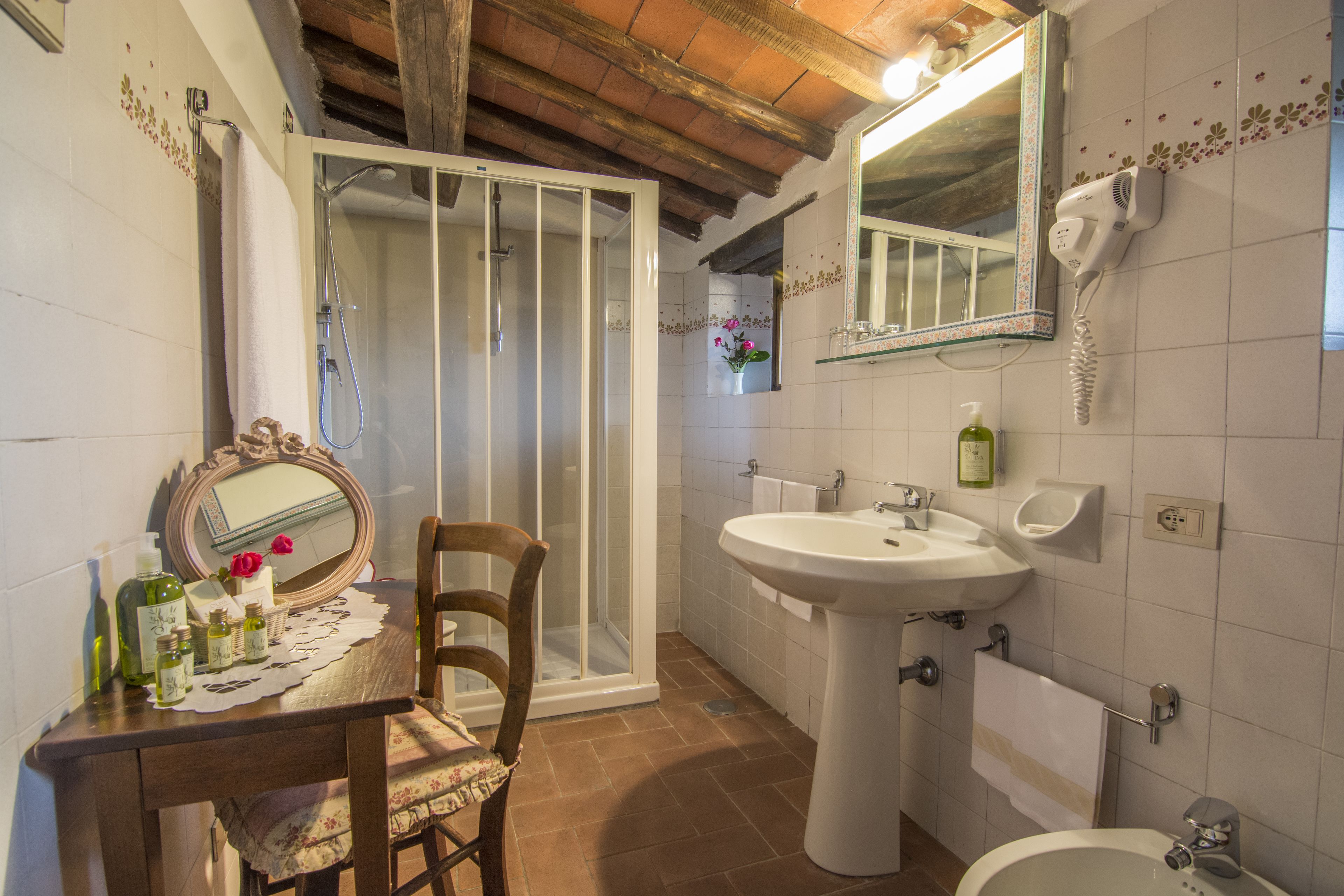 Un bagno con doccia, lavandino e WC.