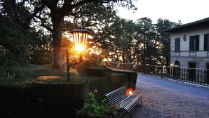 Un banc dans un parc, avec un lampadaire et un bâtiment en arrière-plan.