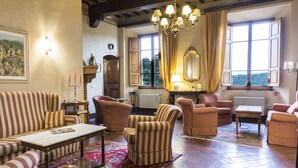 Un salon spacieux avec des canapés à rayures, une table basse et un lustre.