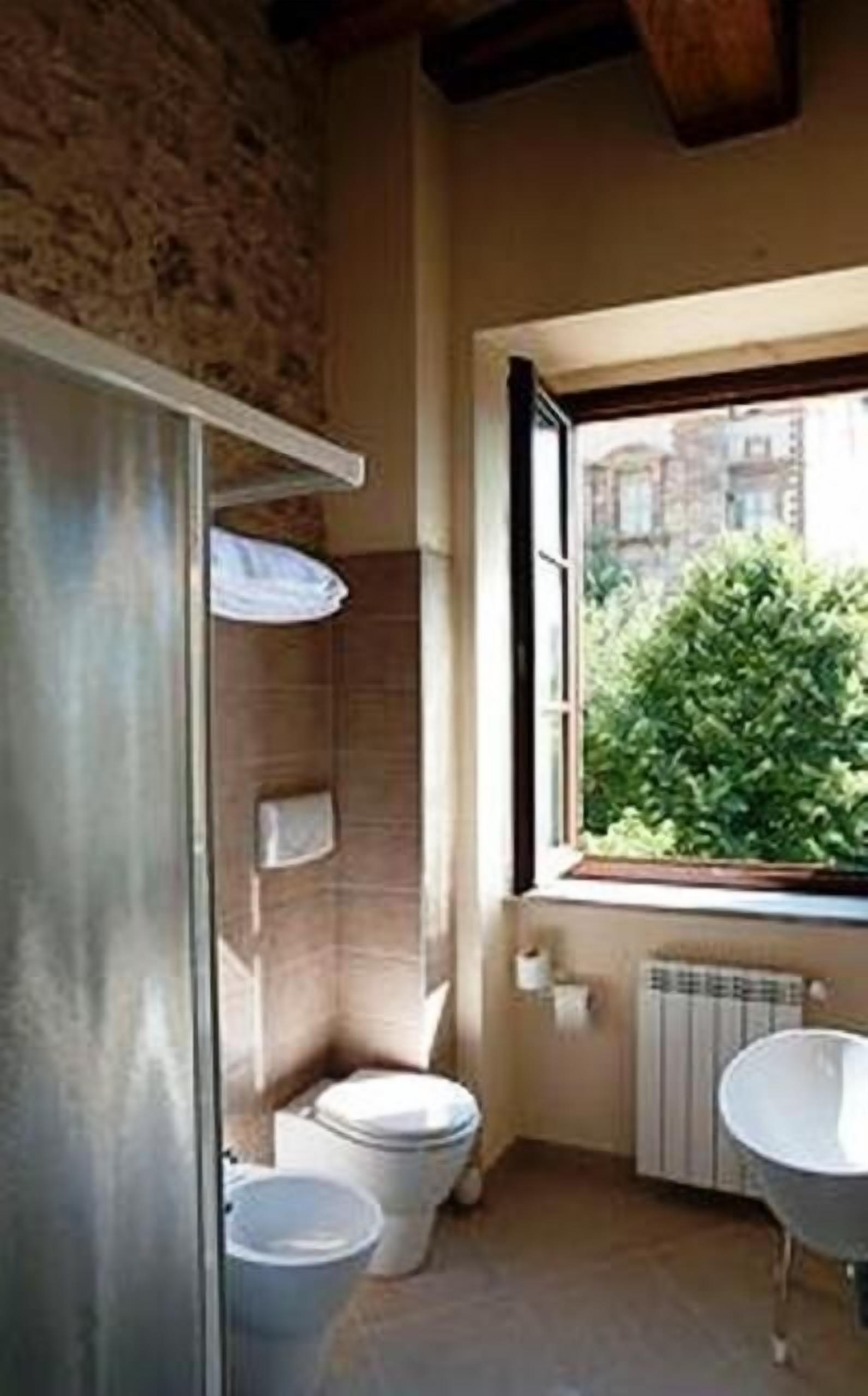 Une petite salle de bain comprenant des toilettes, un lavabo et une fenêtre.