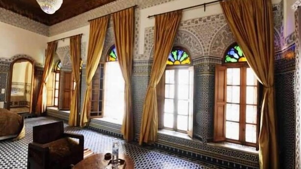 A room with patterned tile flooring, large windows with curtains, and a chandelier. - Riad au 20 Jasmins (Fes)
