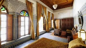 A room with patterned tile flooring, a bed, a desk, and a chair. - Riad au 20 Jasmins (Fes)