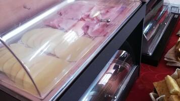 Un bufé con distintos alimentos, incluyendo embutidos y pan.