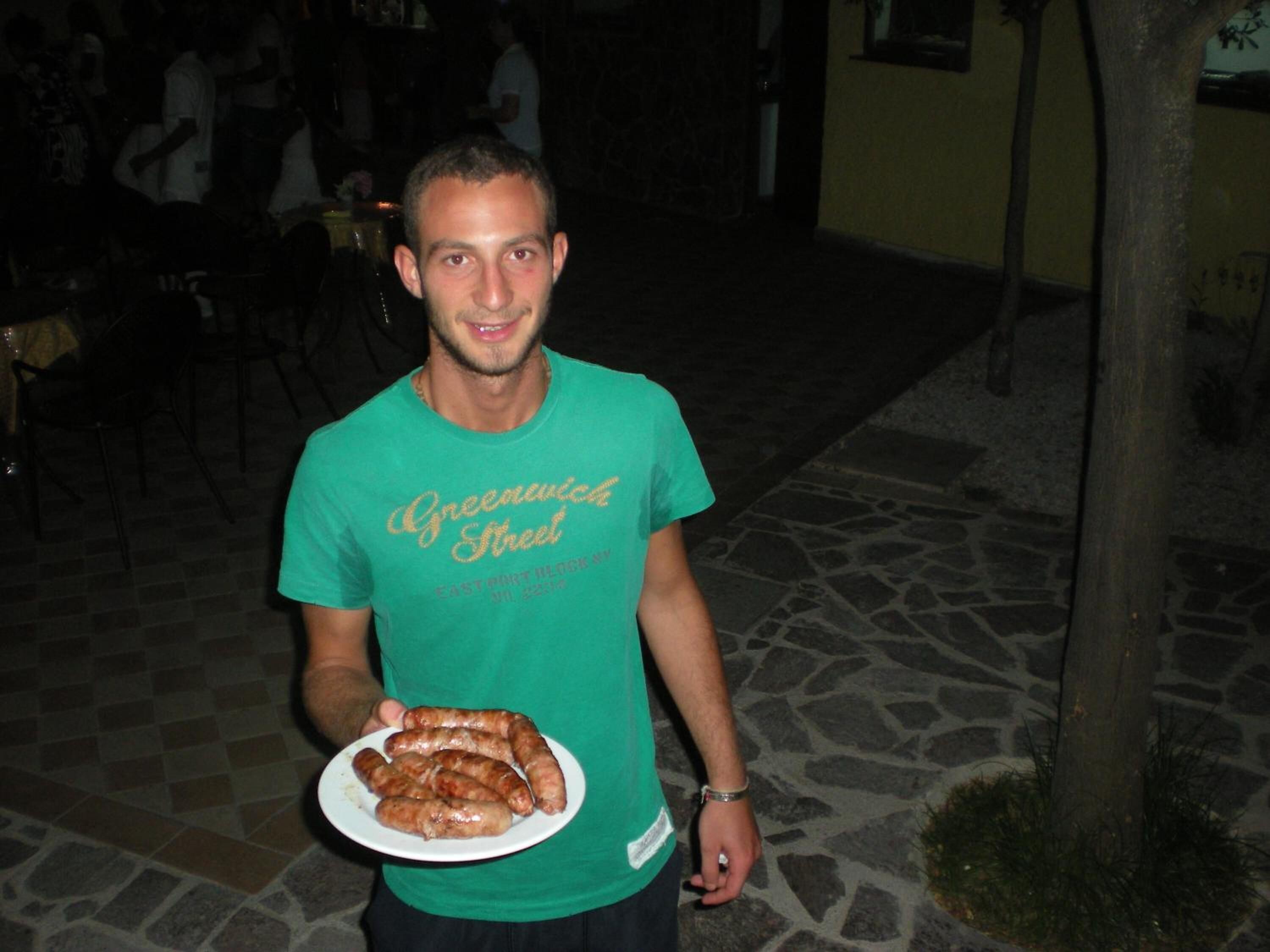 Una persona sosteniendo un plato de salchichas.