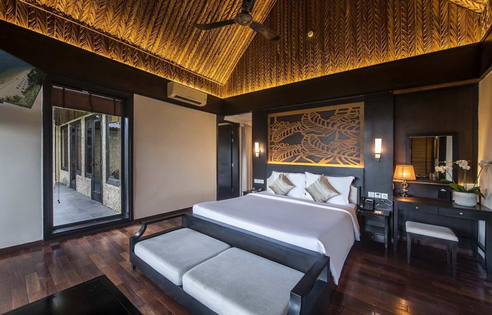 Ein modernes Hotelzimmer mit einem großen Bett, einem Schreibtisch und einer Sitzecke.