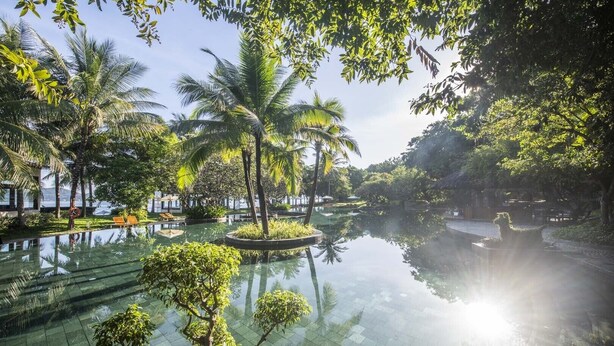 A serene pool area with palm trees and a clear view of the ocean. - Hon Tam Resort (Nha Trang)
