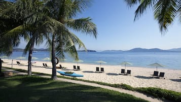 Privat strand, vit sandstrand, parasoller och strandhanddukar