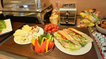 A buffet with various food items including sandwiches, salads, and fruits.