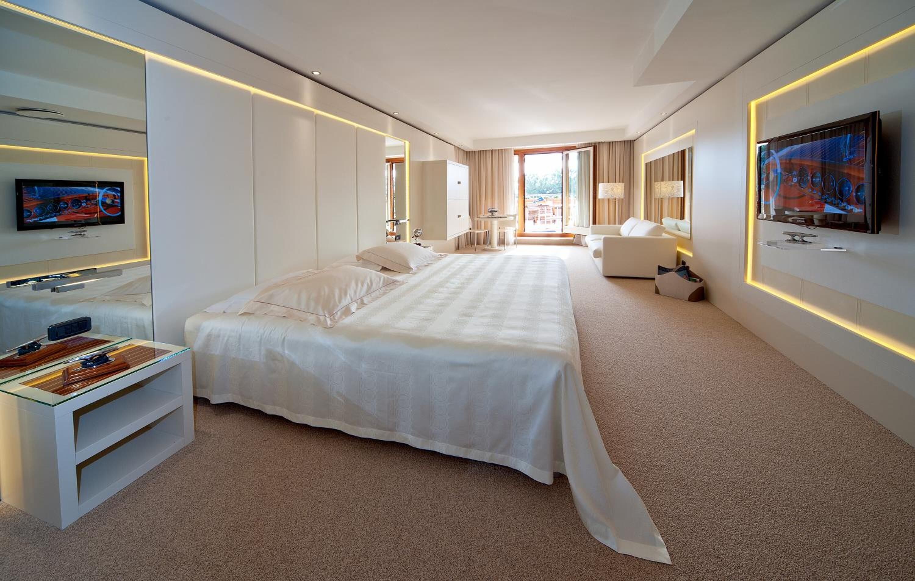Une chambre d’hôtel moderne dotée d’un grand lit, d’un bureau, d’une télévision et offrant une vue sur le balcon.