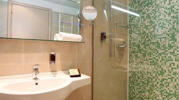 A modern bathroom with a glass-enclosed shower, a sink, and a mirror.