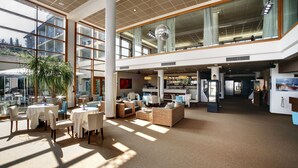 A spacious lobby with high ceilings, large windows, and a bar area. - Cocca Hotel Royal Thai SPA (Sarnico)