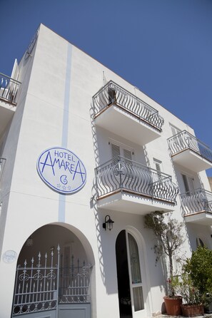 A hotel with balconies, a sign reading "HOTEL AMAREA," and a large arched entrance. - Hotel Amarea (Lipari)
