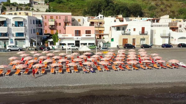 A beachside area with numerous beach umbrellas and lounge chairs arranged in rows. - Hotel Amarea (Lipari)