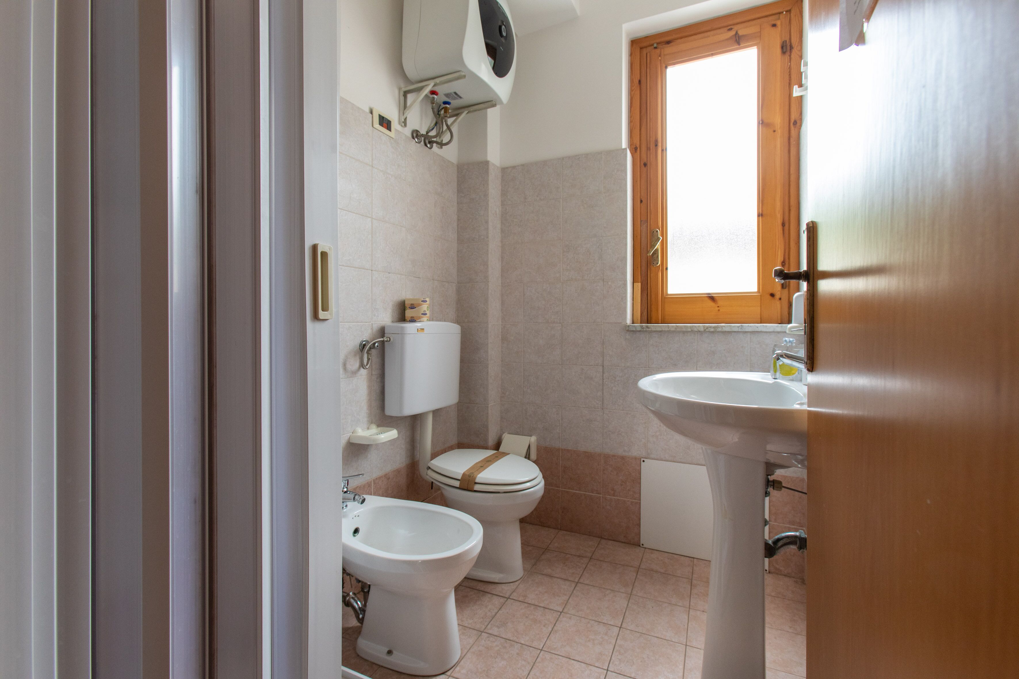 Un baño con inodoro, bidé y lavabo.