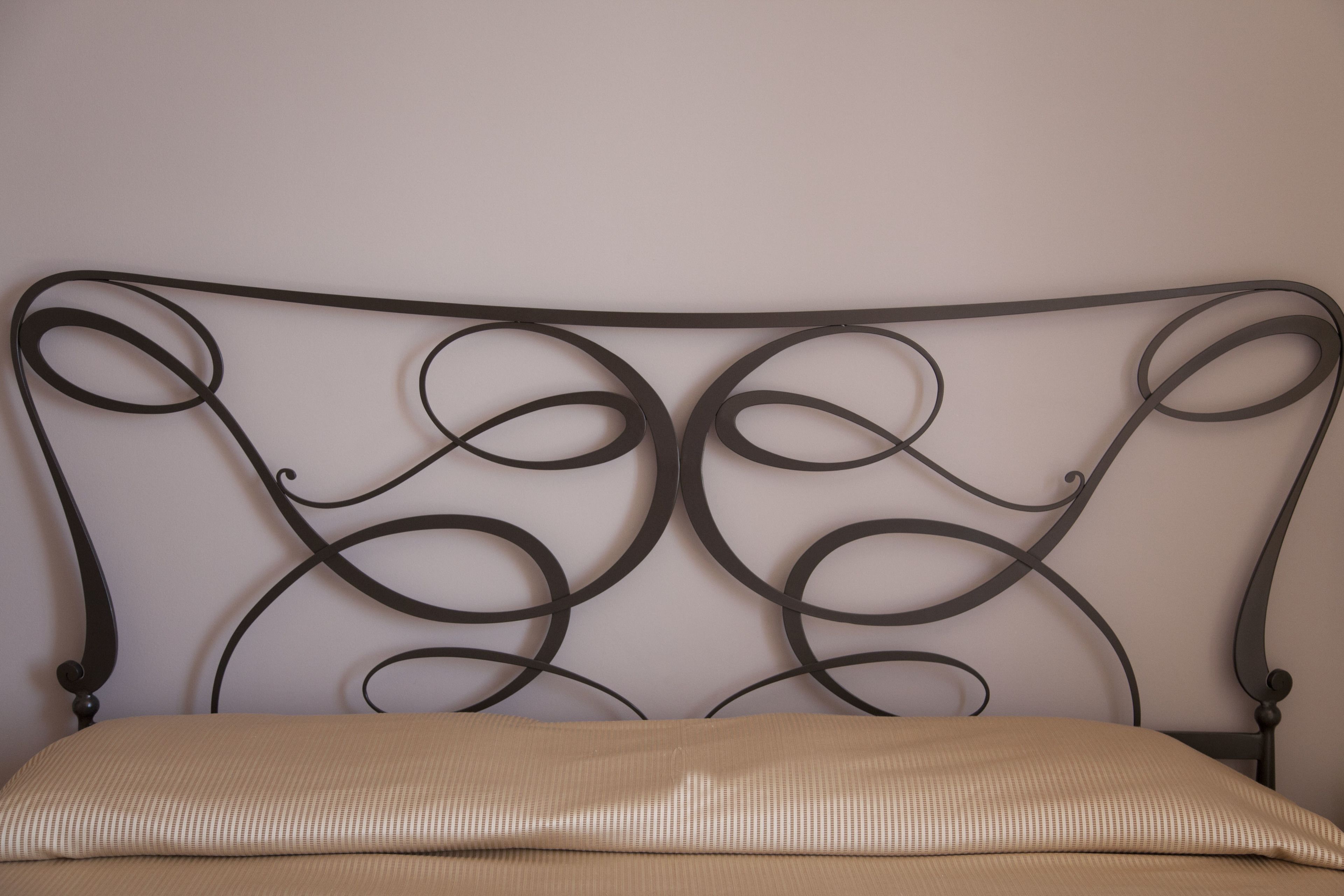 A bed with a metal headboard featuring a circular design.