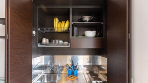 Une cuisine compacte dotée d’un évier encastré, d’un égouttoir et d’un porte-ustensiles.