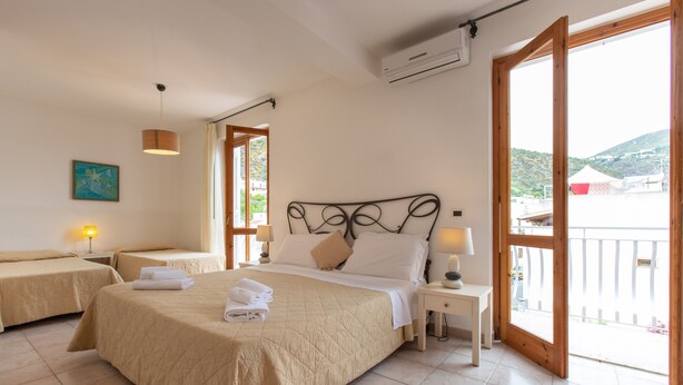 Une chambre d’hôtel avec deux lits, une grande fenêtre et une vue sur l’extérieur.