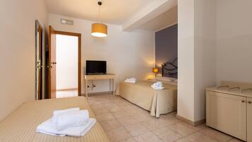 Ein Hotelzimmer mit Bett, Schreibtisch, Fernseher, Nachttisch und Badezimmer.