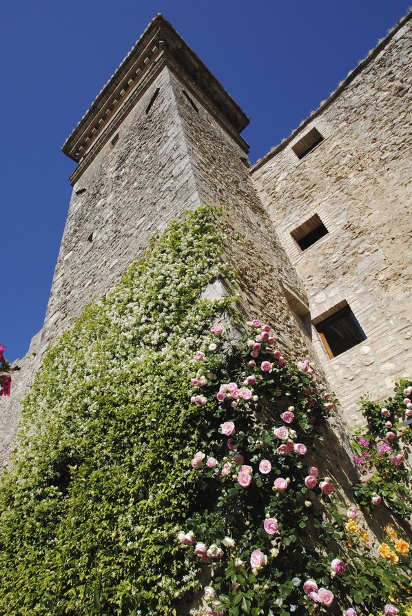 A stone tower with a narrow window and a small door. - Albergo Torre Sangiovanni (Todi)
