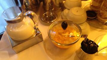 A table with a glass pitcher, a bowl with a lid, and a metal cup with coffee beans.