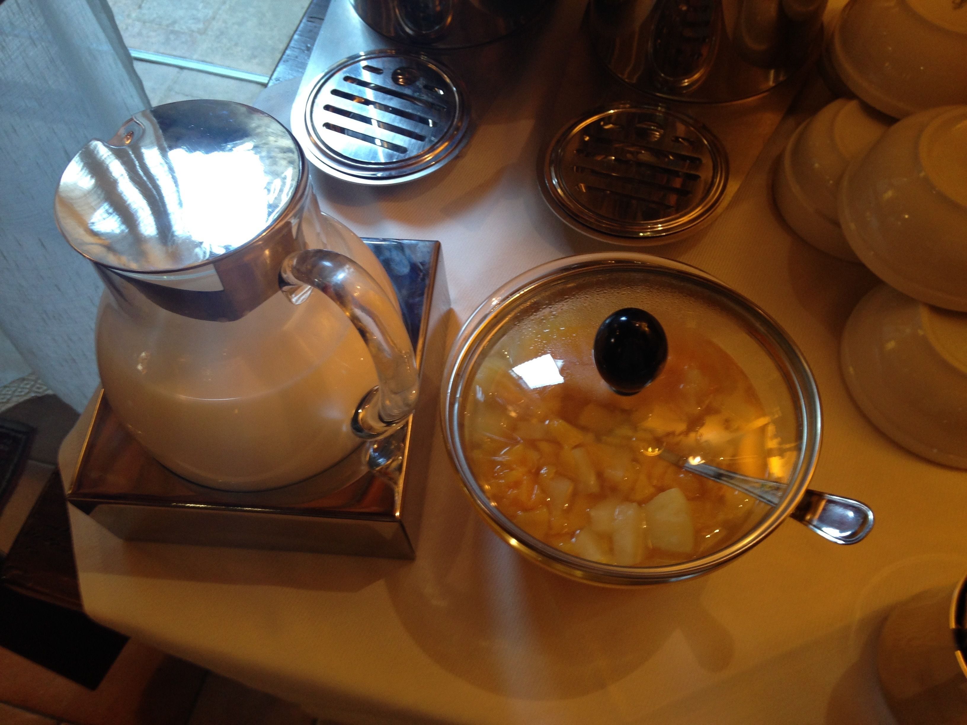 A kitchen counter with a coffee maker, a bowl of soup, and several plates.