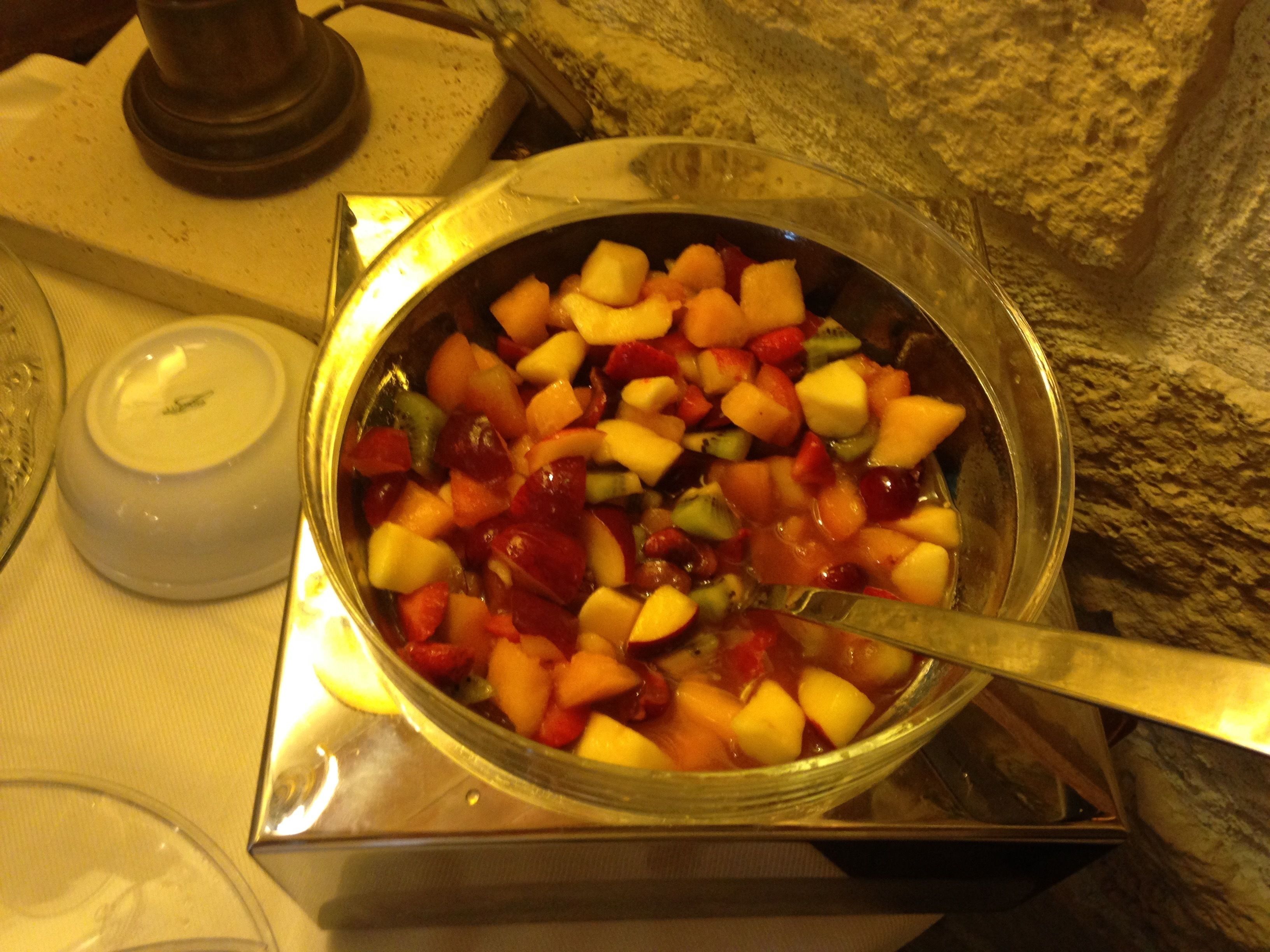Un tazón de ensalada de frutas variadas sobre una mesa.