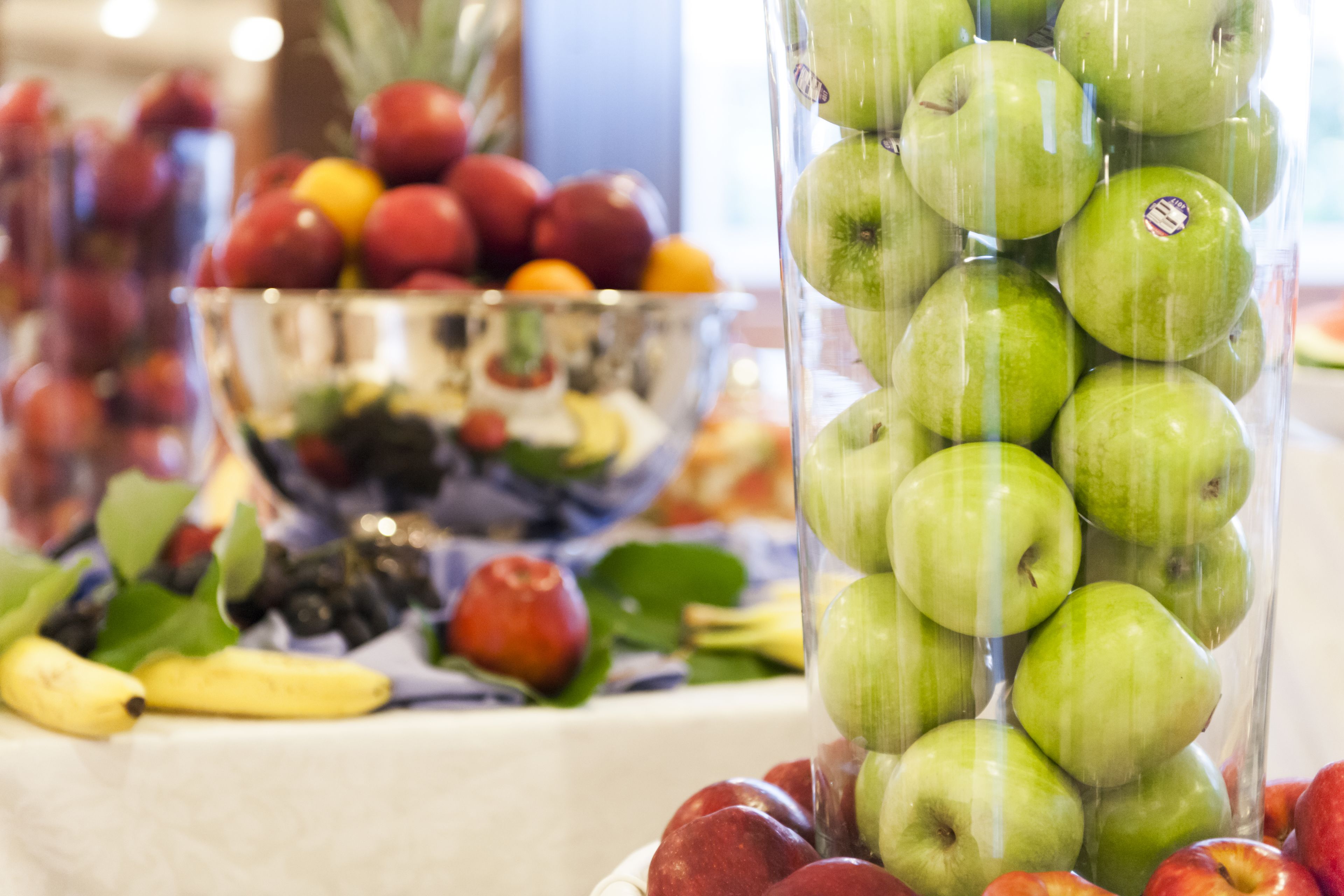 Una mesa con diversas frutas como manzanas, plátanos y naranjas.