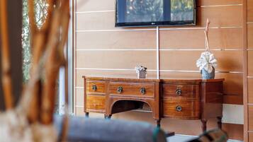 Una sala de estar moderna con un mueble de madera, un televisor de pantalla plana y un ventanal grande.