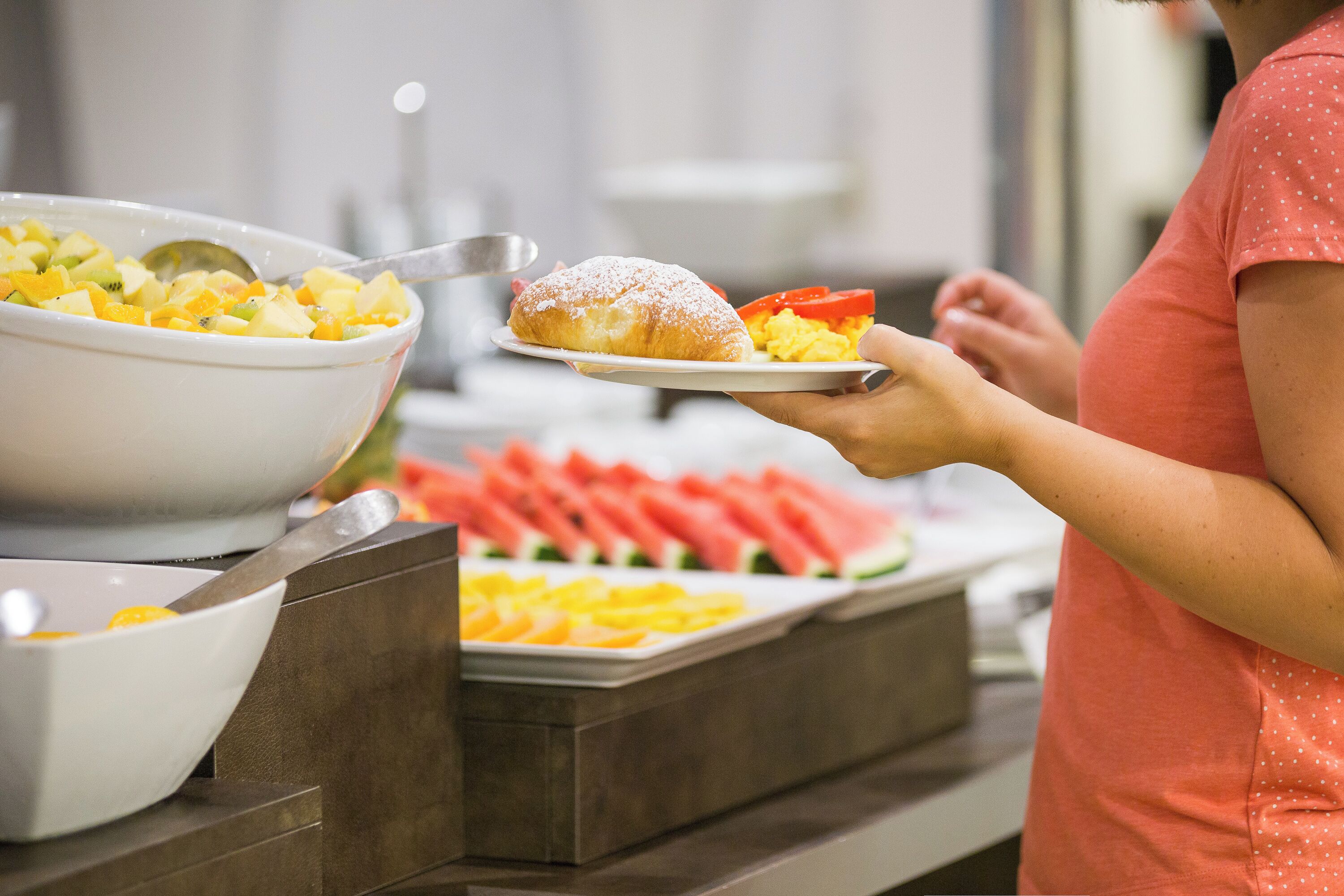 Un bufé con diversos alimentos, incluyendo frutas y un pastel.