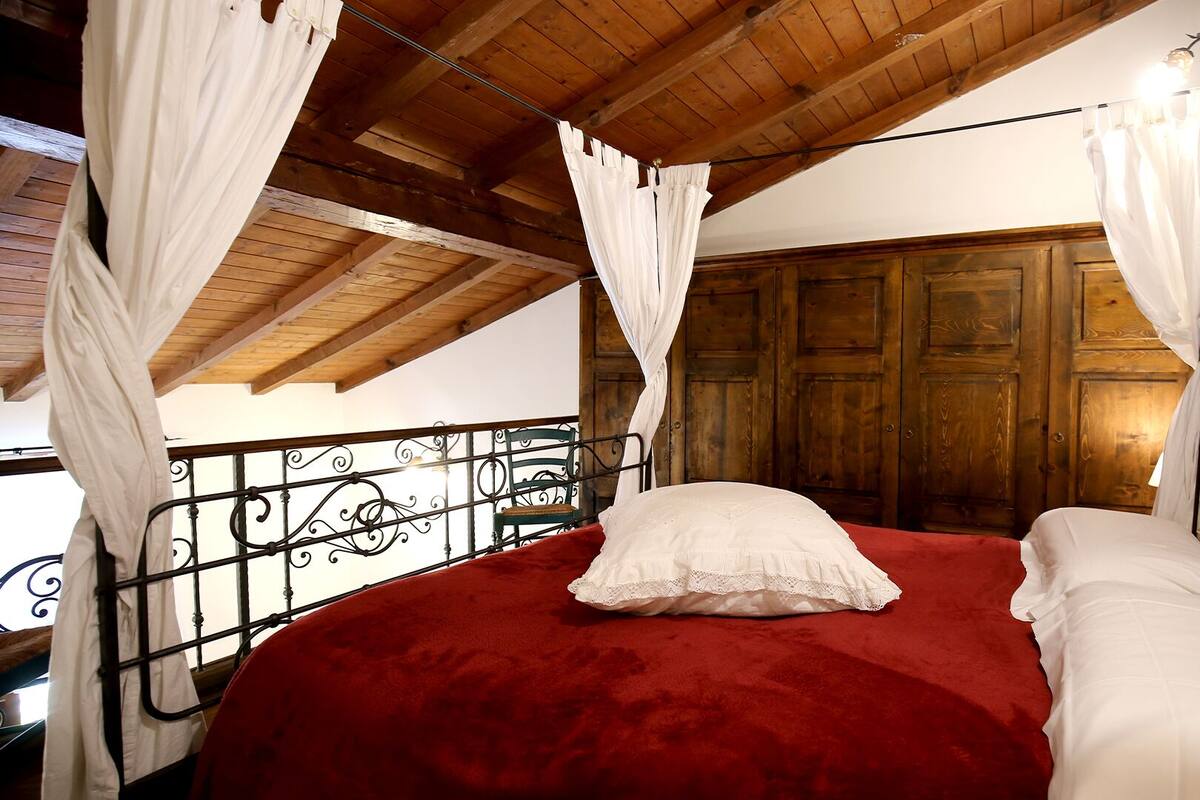 Un dormitorio con cama, techo de madera y cabecero de metal.