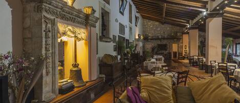 A cozy interior with a sofa, a fireplace, and a dining area.
