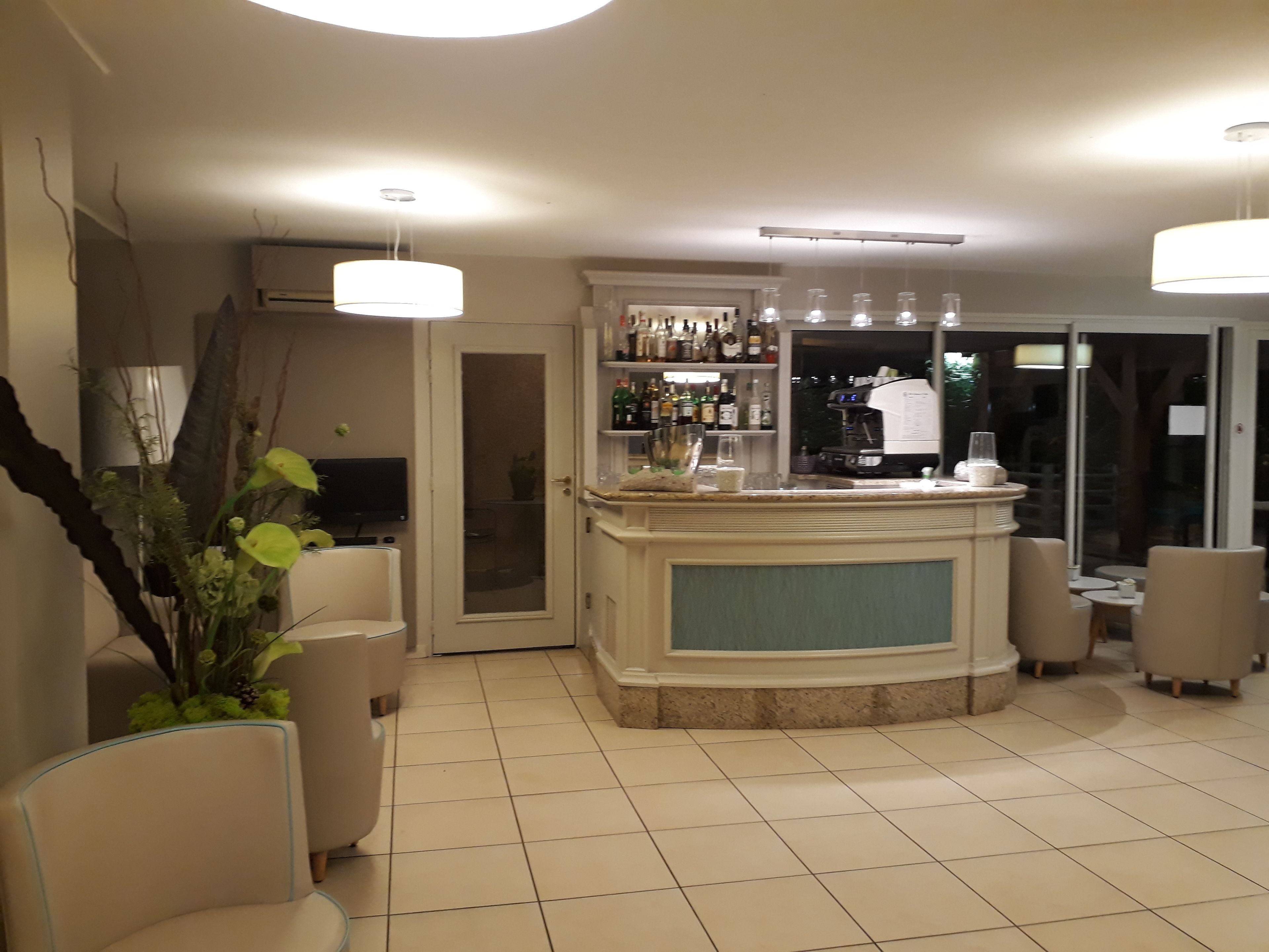 Un espace bar avec un comptoir, des chaises et un téléviseur.