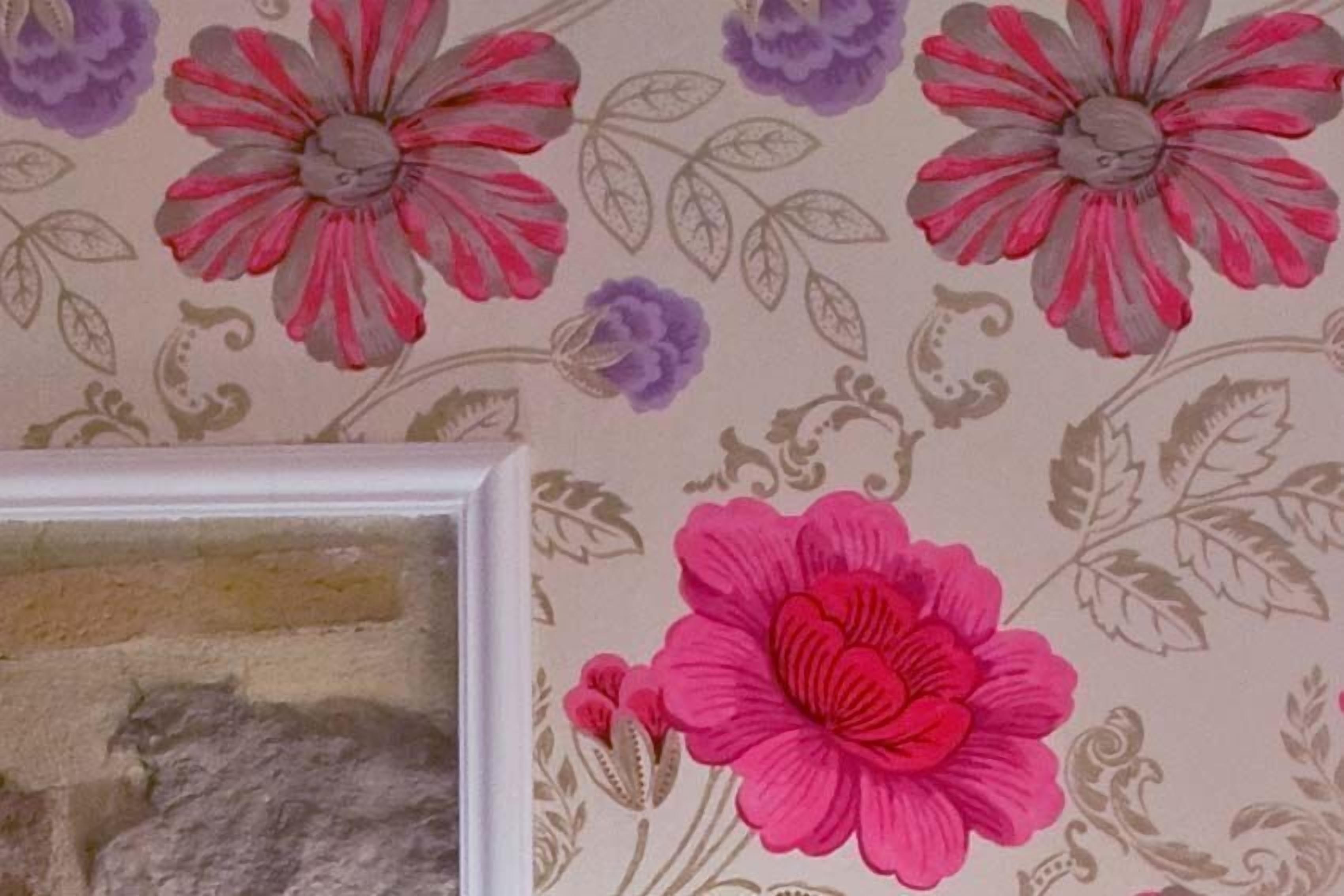 Un mur recouvert d’un papier peint à motifs floraux.