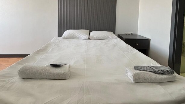 A modern hotel room with a large bed, a bedside table, and a wall-mounted panel. - Hotel Abro Necatibey (Ankara)