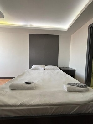 A modern hotel room with a large bed, a bedside table, and a wall-mounted panel. - Hotel Abro Necatibey (Ankara)