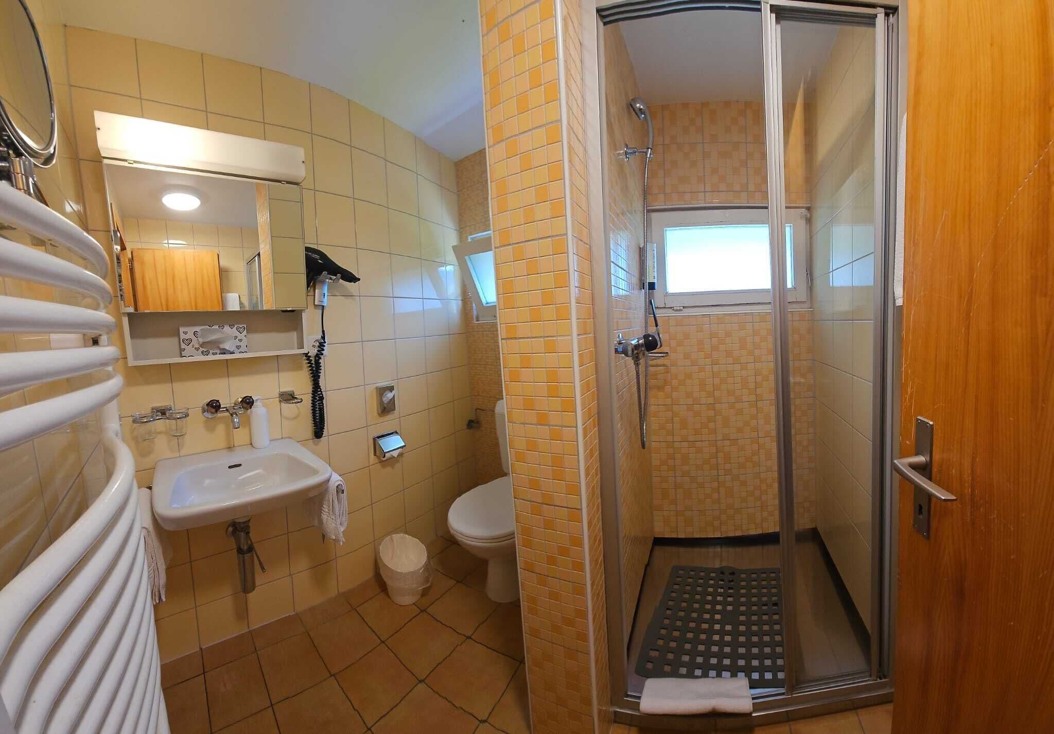A bathroom with a sink, toilet, and shower.