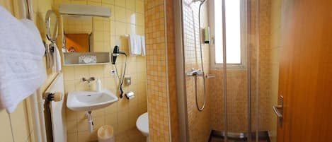 A bathroom with a sink, toilet, and shower area.