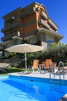 Una piscina al aire libre de temporada, sombrillas